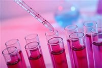 Dripping reagent into test tube with red liquid, closeup. Laboratory analysis - stock image