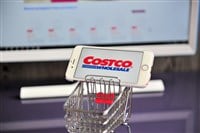 Costco Wholesale logo in mobile phone in shopping cart. — Stock Editorial Photography