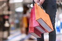 Hand of woman carrying shopping bags on shopping malls background. happiness, consumerism, sale and people concept. — Photo