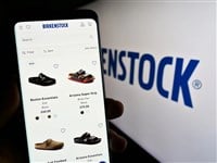 Stuttgart, Germany - 07-24-2023: Person holding cellphone with webpage of shoe company Birkenstock Group B.V. Co. KG on screen in front of logo. Focus on center of phone display. — Stock Editorial Photography