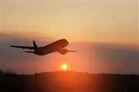 Airplane taking off at the sunset sky. Silhouette of aircraft in the sky.