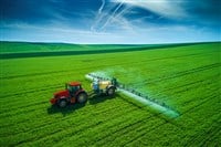 Aerial view of farming tractor plowing and spraying on field — Photo