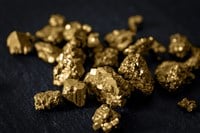 Gold mining and and investment in precious metals concept with close up on golden nuggets on a black background