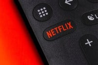 Netflix button on the remote controller on red background. Netflix - Stock Editorial Photography