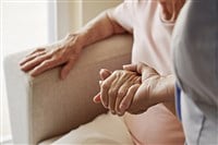 Mature female in elderly care facility gets help from hospital personnel nurse. Senior woman with aged wrinkled skin & care giver, hands close up. Grand mother everyday life. Background, copy space. — Photo