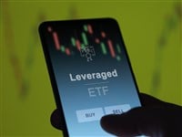 An investor analyzing the leveraged etf fund on a screen. A phone shows the prices of Leveraged - stock image