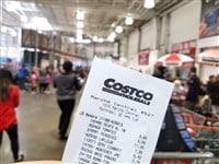 MONTREAL, CANADA - OCTOBER 5, 2018: A hand holding a receipt with the brand name and logo in Costco warehouse. Costco is an American corporation which operates a chain of membership only warehouses. — Stock Editorial Photography