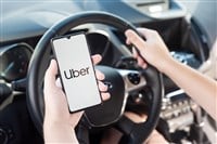 Wroclaw, Poland - AUG 25, 2020: Uber driver holding smartphone in car. Uber is sharing-economy service for ubran transport. - Stock Editorial Photography