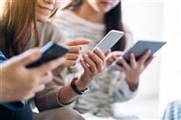 Group of people using and looking at mobile phone and tablet pc while sitting together