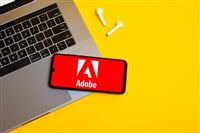 Kyoto city, Japan - July 31, 2023: Adobe logo on the smartphone screen is placed on the Apple macbook keyboard on yellow desk background. — Stock Editorial Photography