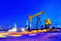 Night view of an oil derrick pumping crude oil at an oil field in Daqing, northeast Chinas Heilongjiang province, 17 December 2009. — Stock Editorial Photography