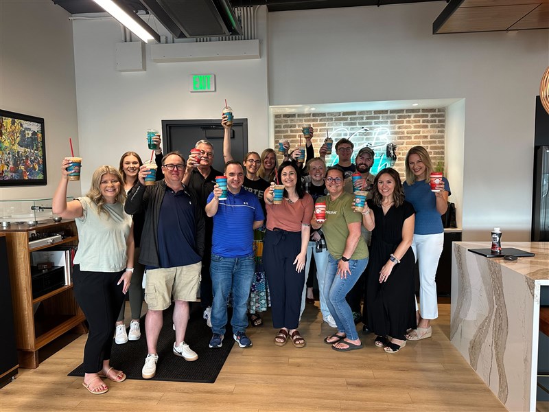 MarketBeat employees enjoying Scooter's coffee in the office together.