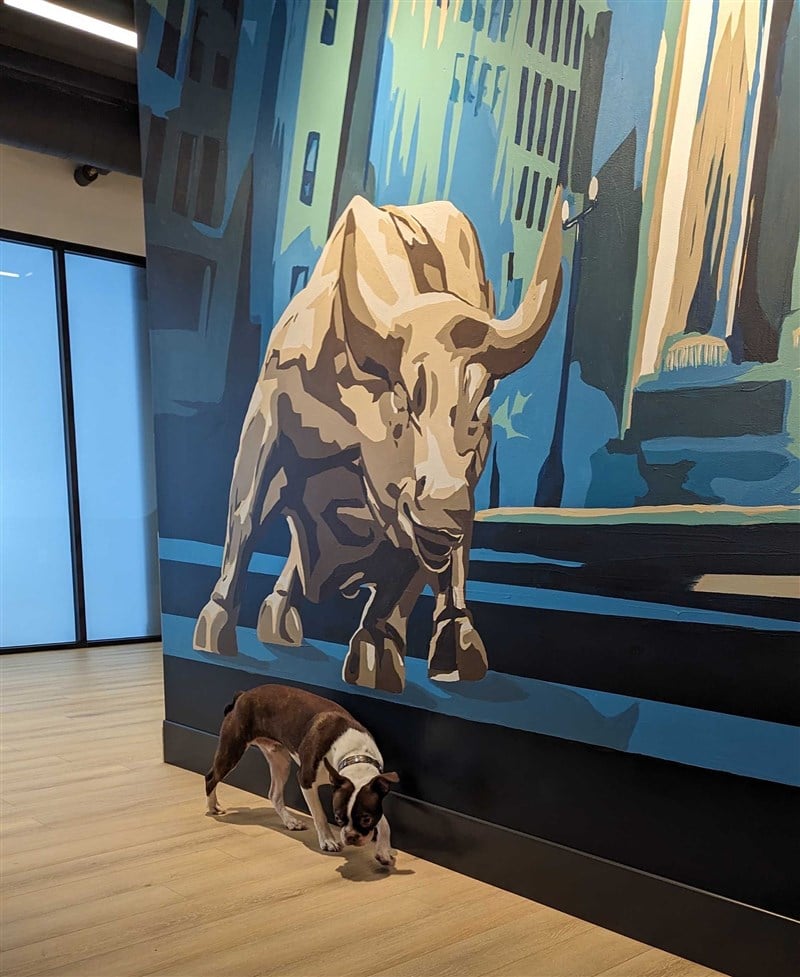 Dog posing in front of bull mural
